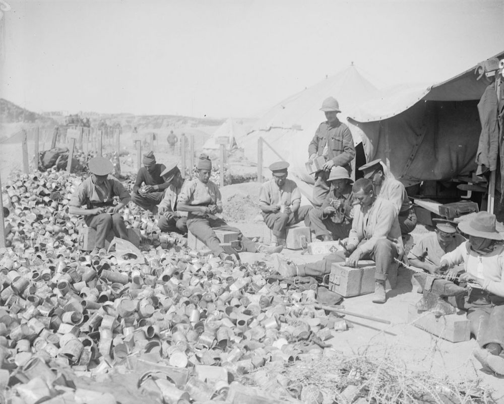 British soldiers making bombs from empty jam tins, filled with old nails and other scraps of metal, and an explosive charge.
